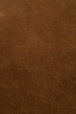 A close-up view of a textured, brown leather surface with visible grain and natural patterns.