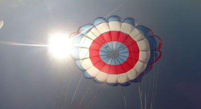 Close-up of hands holding the edge of a bright, multicolored parachute fabric