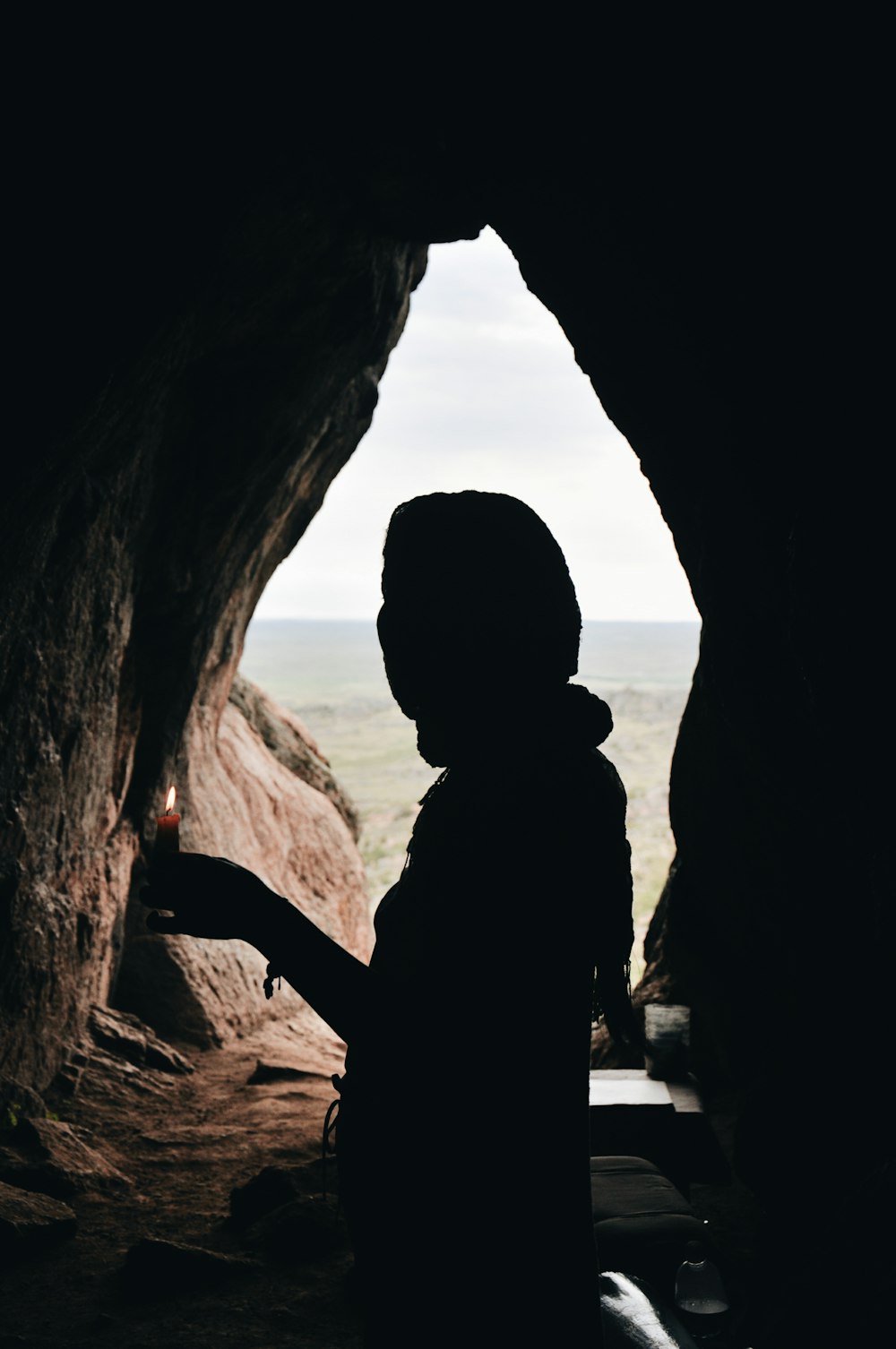 a person standing in a cave with a flashlight