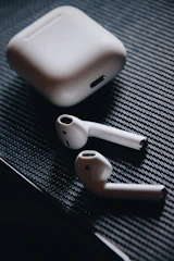 A stylish pair of wireless earbuds with charging case on a marble surface.