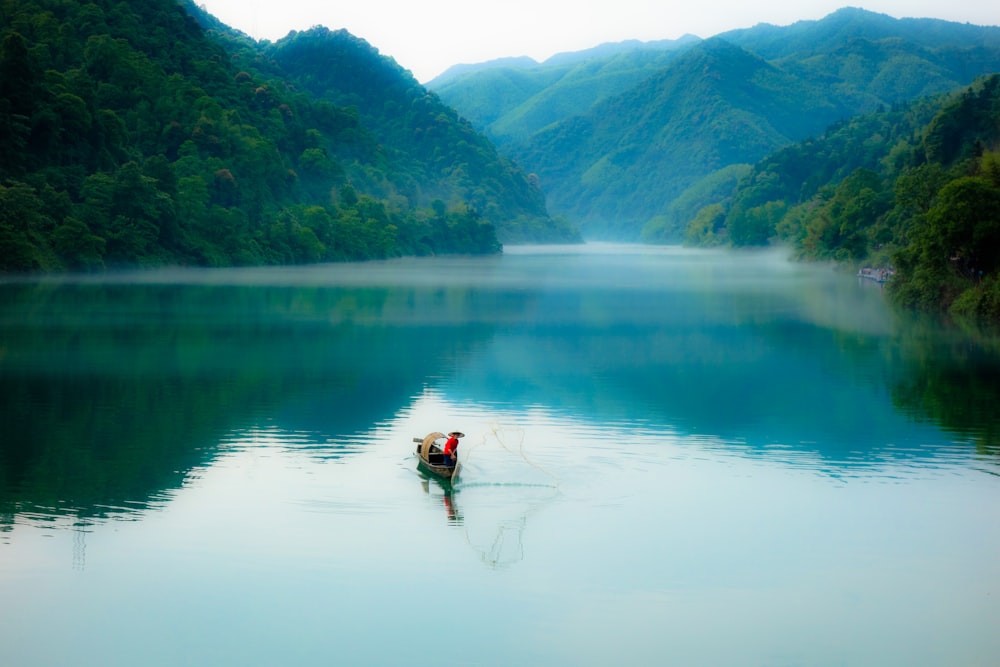 a person in a small boat on a lake