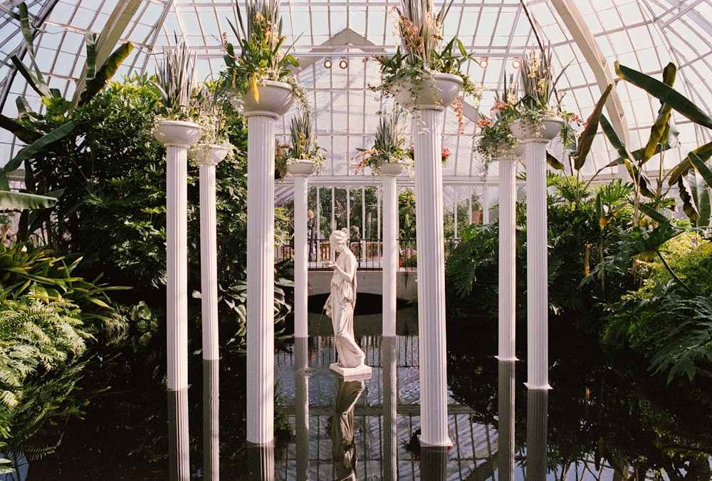 a glass house with a statue in the middle of it