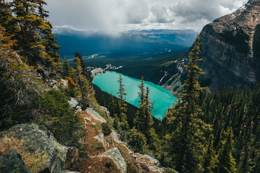 um lago azul cercado por árvores e montanhas