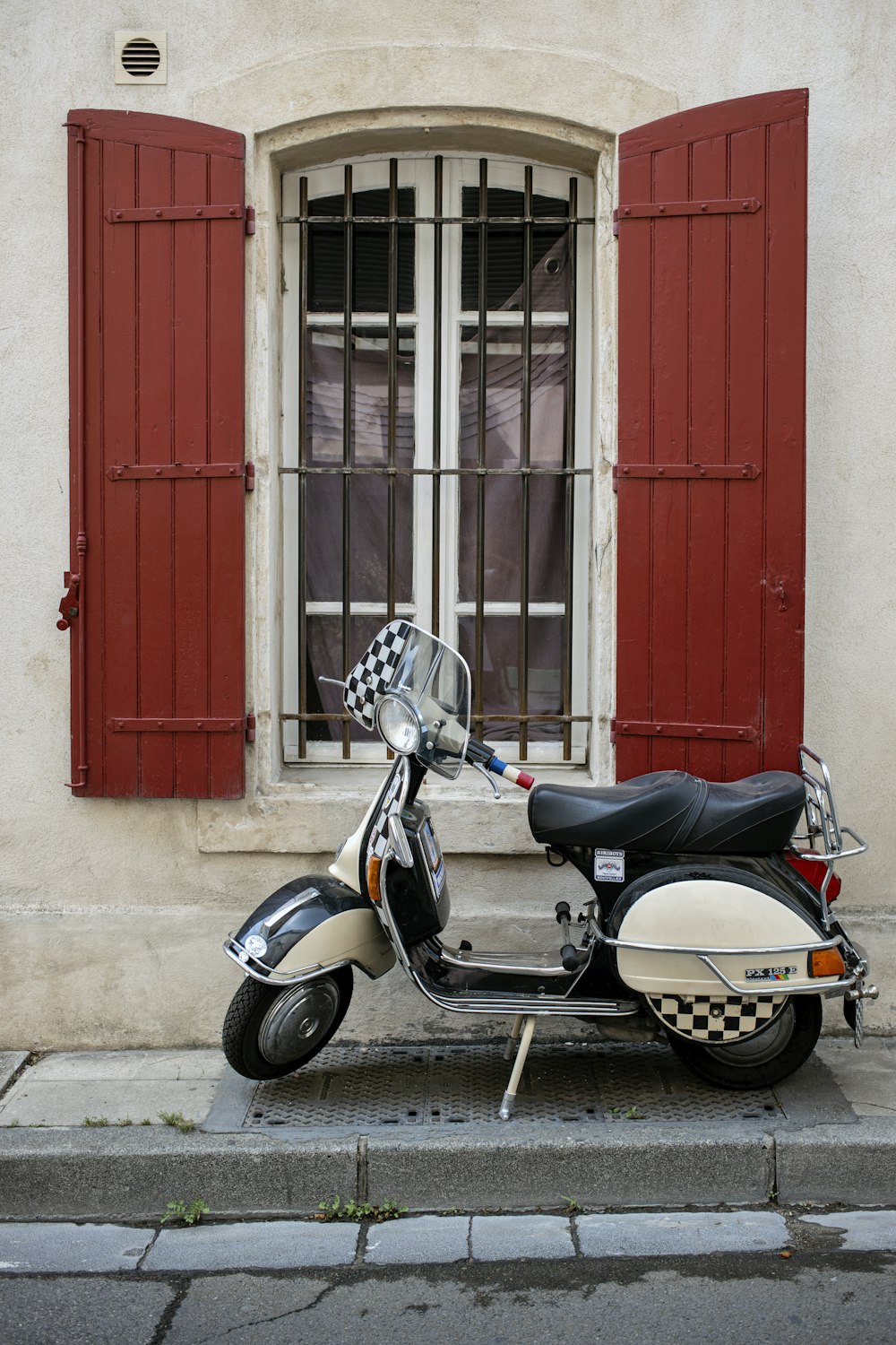 a motor scooter parked in front of a window