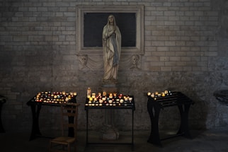 A serene statue of Saint Jude Thaddeus holding a staff, bathed in soft candlelight.