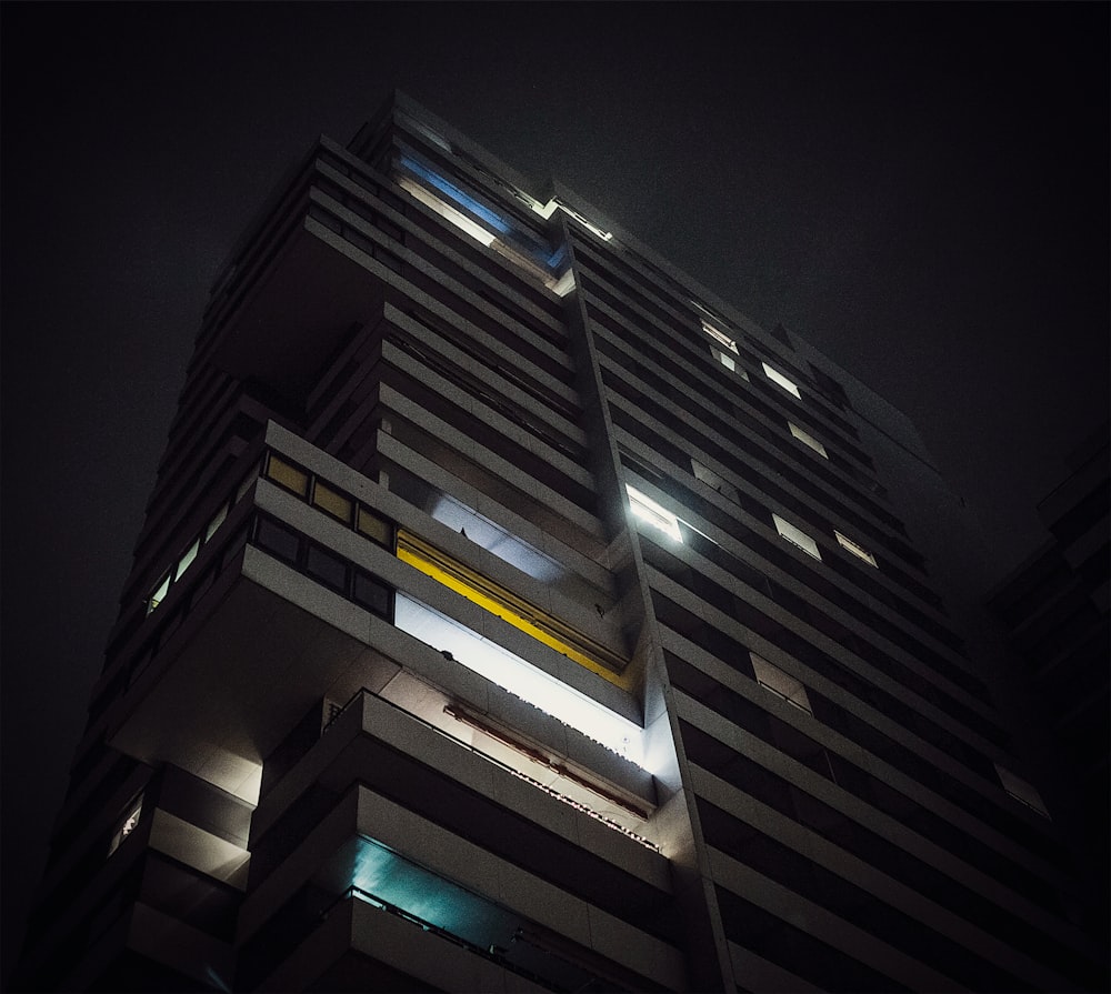 a tall building lit up at night in the dark