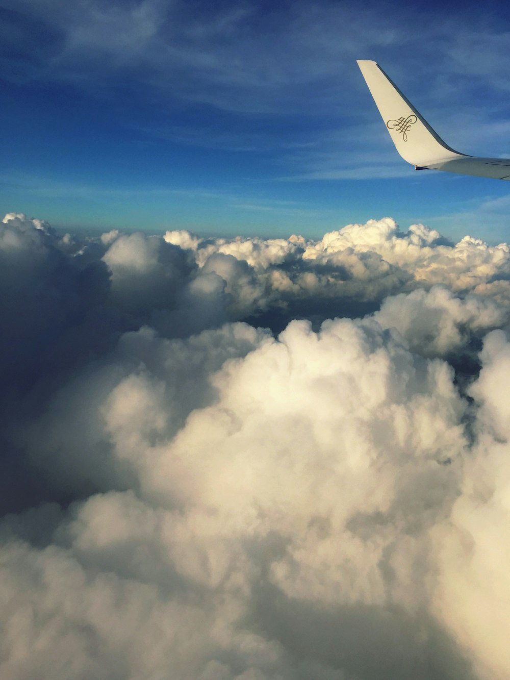 a view of the wing of an airplane above the clouds