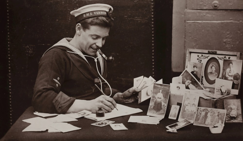 grayscale photography of man writing on paper