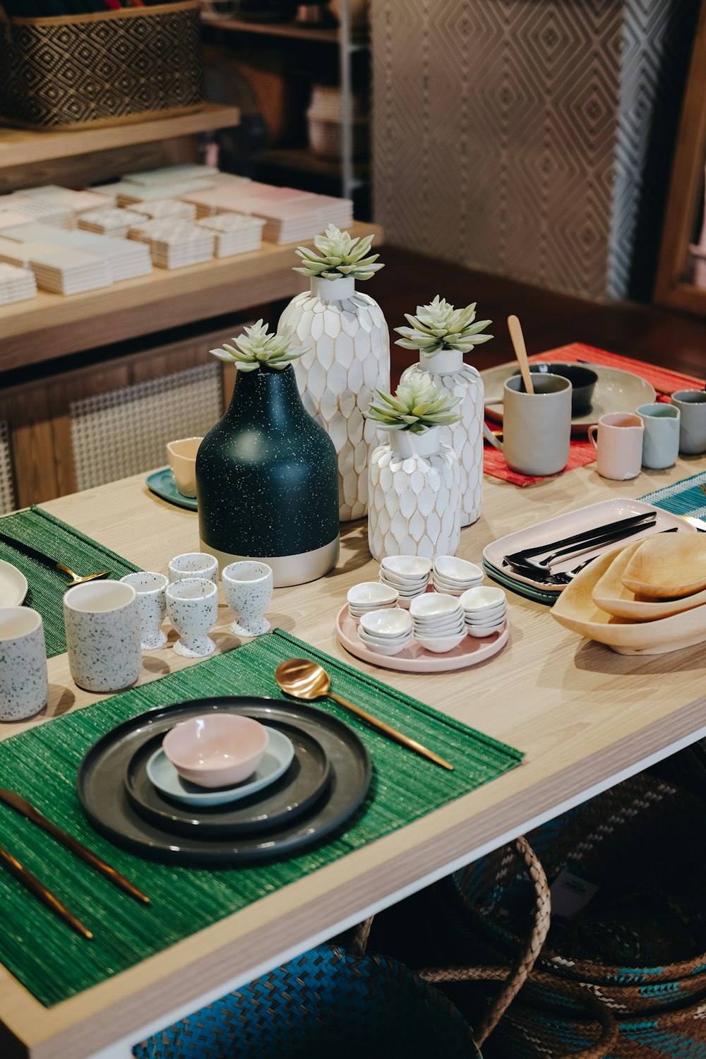 a wooden table topped with plates and cups