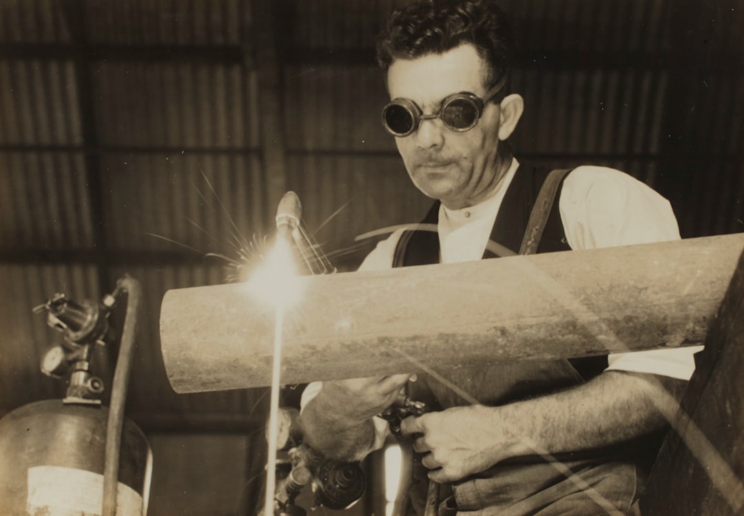 grayscale photography of man welding tube, Kodak Australasia Pty Ltd, Jim Myers Welding Pipe, Abbotsford, Victoria, 1930s