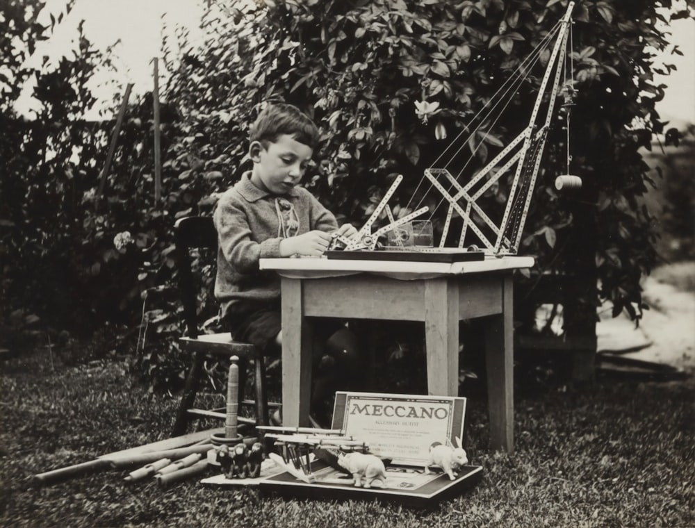 Niño sentado en la silla jugando con el mecano