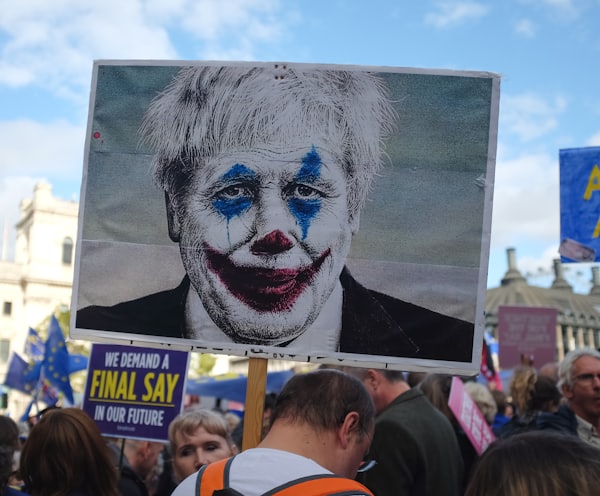 person holding man wearing clown face art