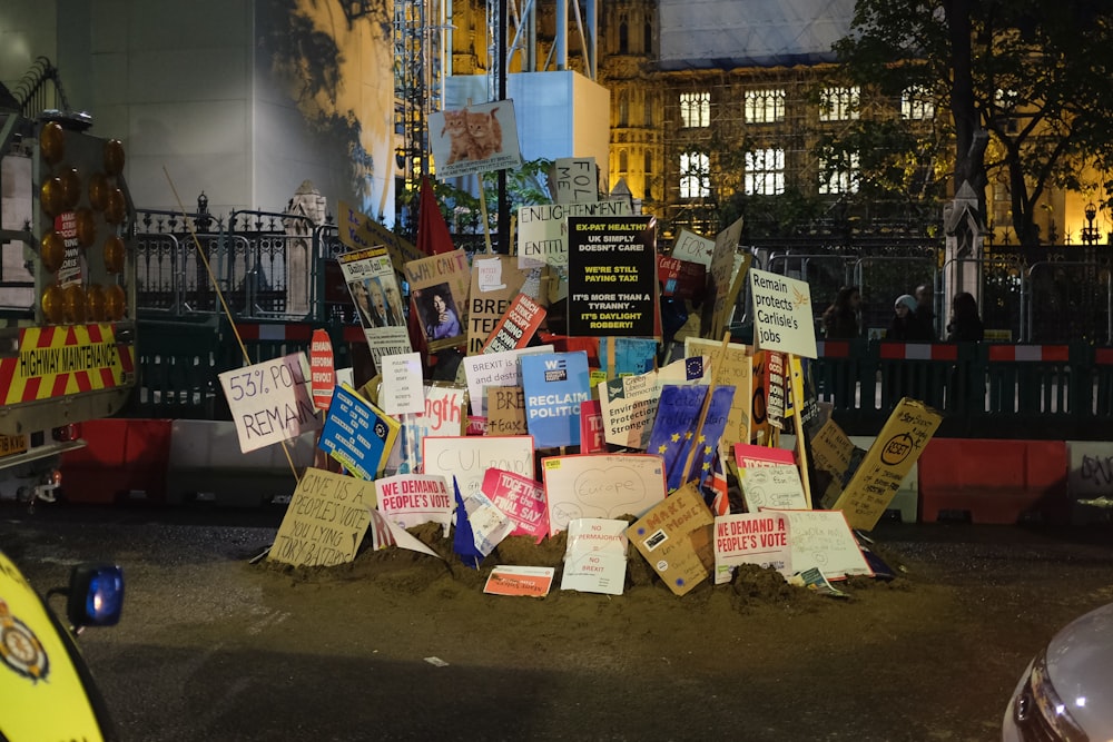 a pile of signs sitting on the side of a road