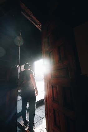 A warm, inviting scene of a person stepping out of a cozy room into a bright, open space symbolizing growth and change.