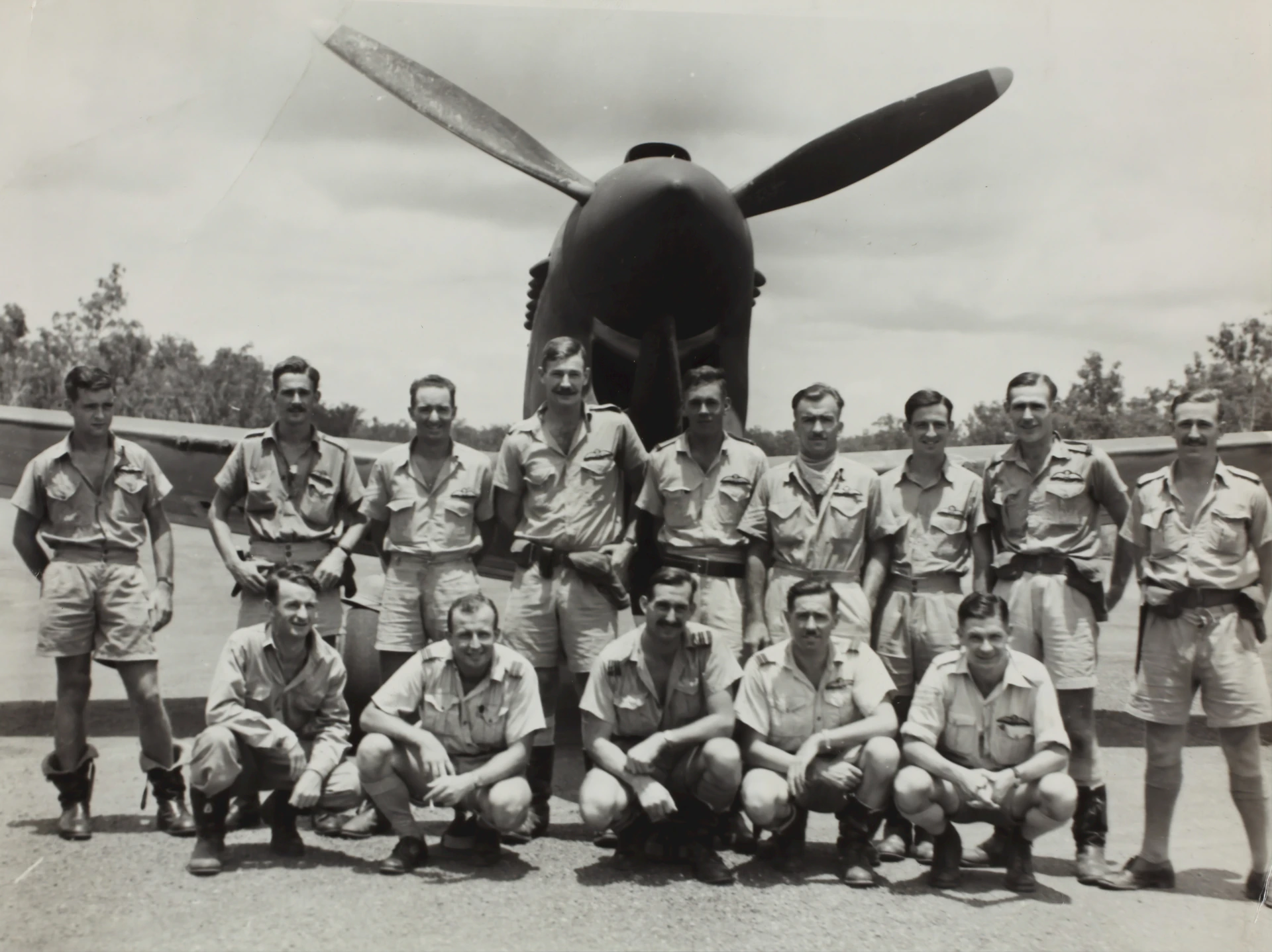 An old black-and-white photo of paratroopers preparing for a jump, capturing the spirit of camaraderie and bravery.