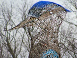 Side view of a string art sculpture depicting a bird in flight with vibrant threads.
