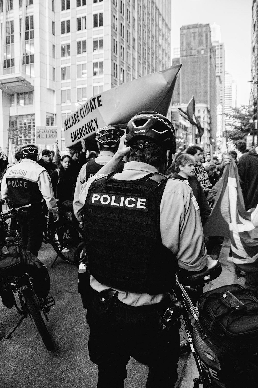 a black and white photo of a police officer talking on a cell phone