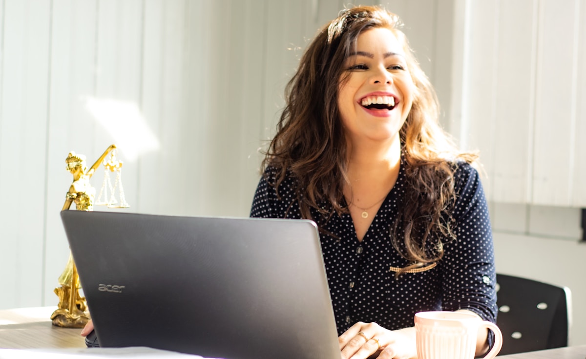 woman smiling in front of laptop computer