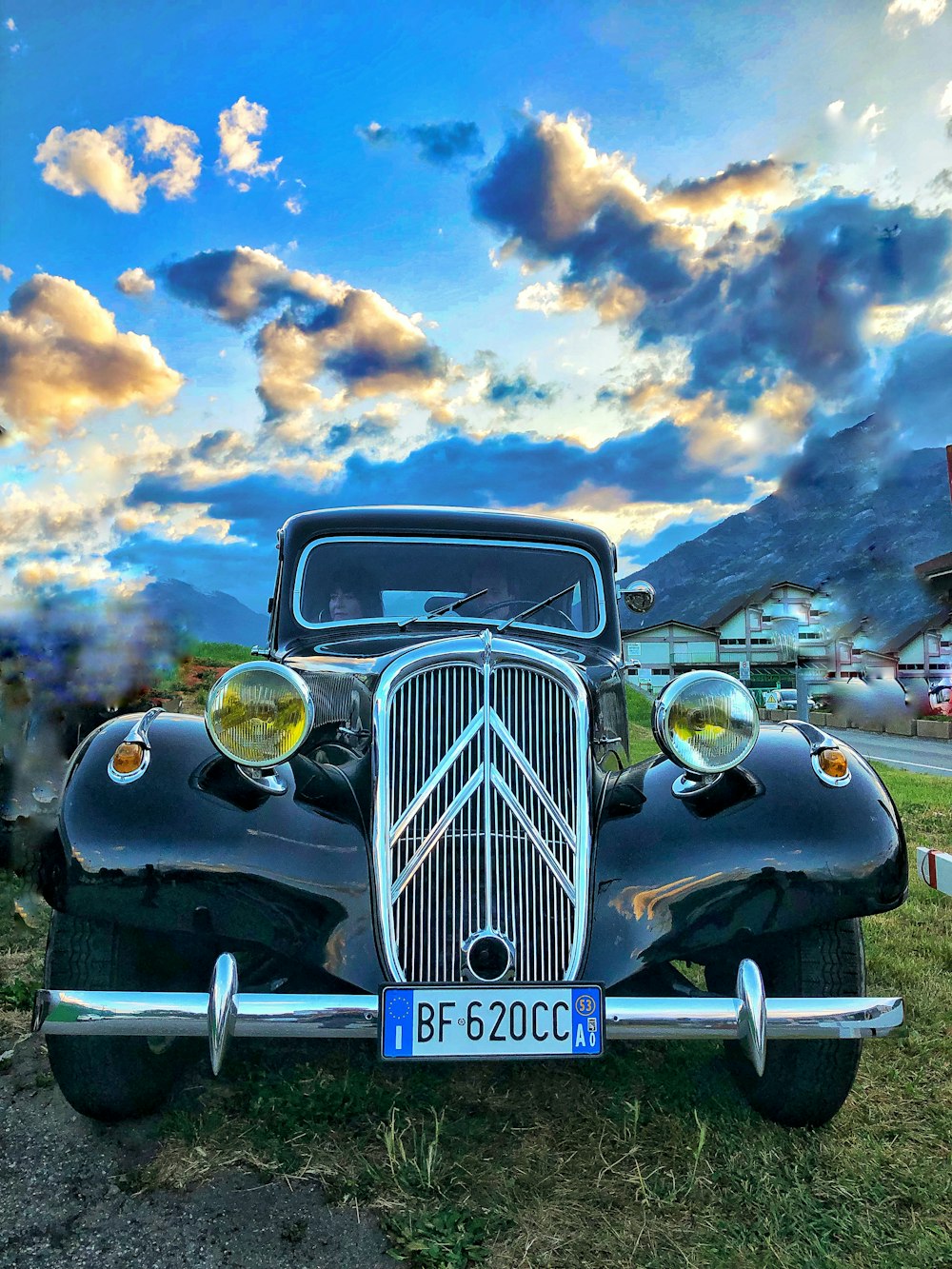 a classic car is parked in a field