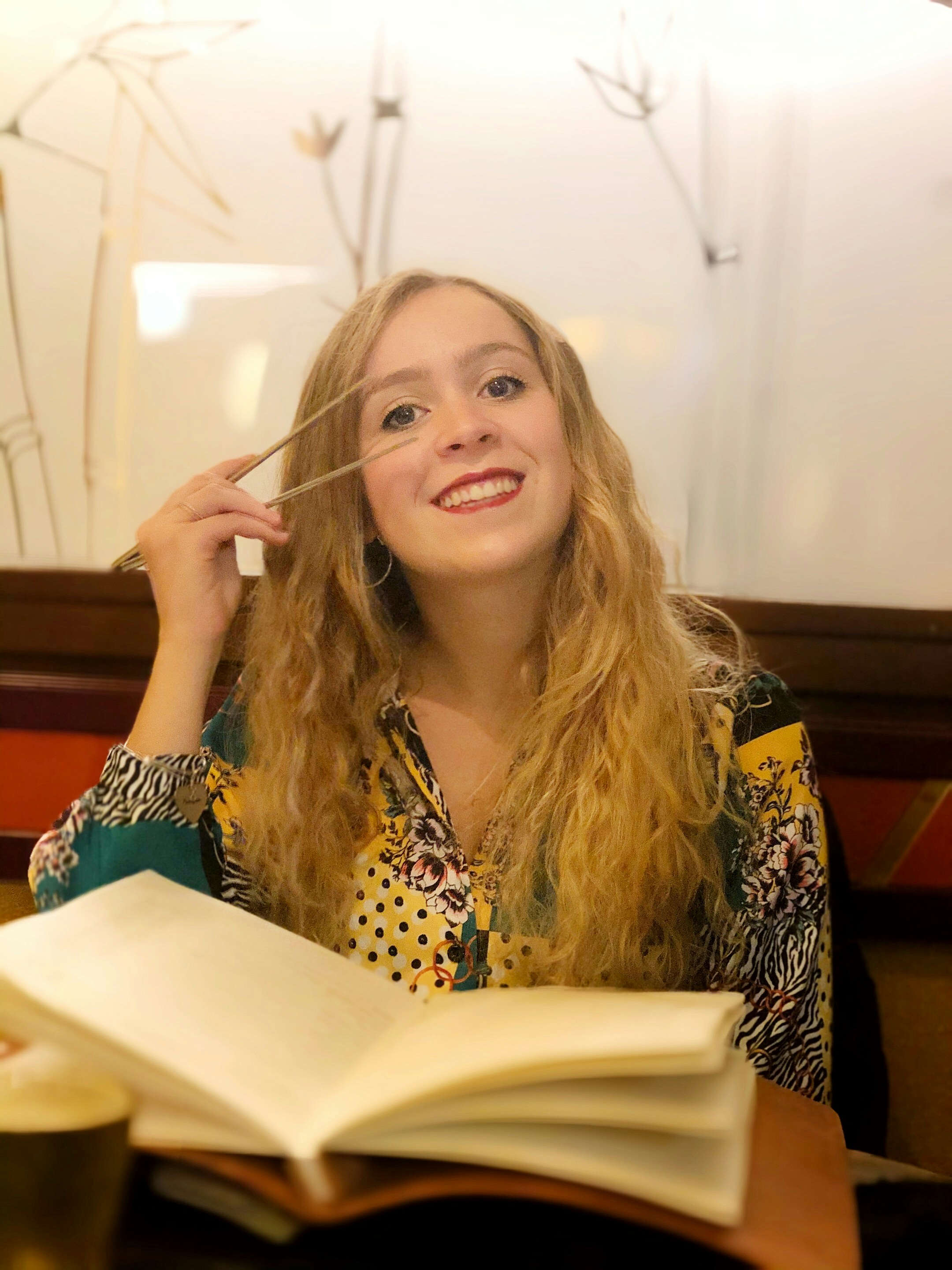 a woman sitting at a table with an open book