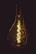 A glowing light bulb with visible filament emits a warm, golden light against a dark background. The intricate design of the filament is prominently displayed, creating a sense of vintage style and ambiance.