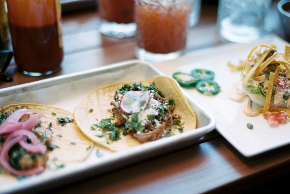 a couple of tacos sitting on top of a white plate