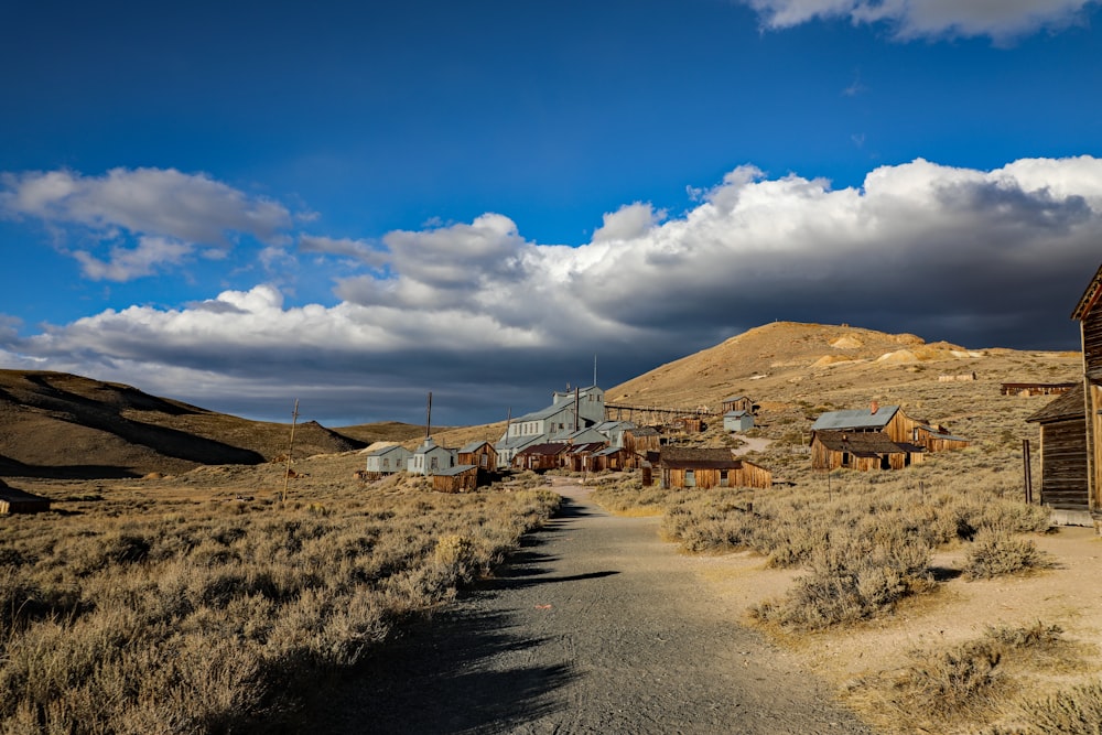 a dirt road leading to a building in the middle of nowhere