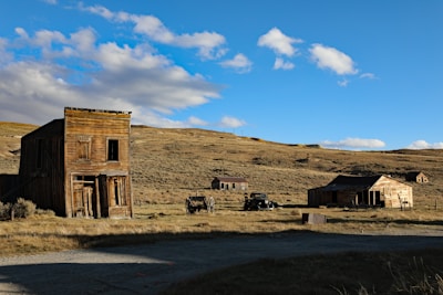 an old wooden building sitting in the middle of a field