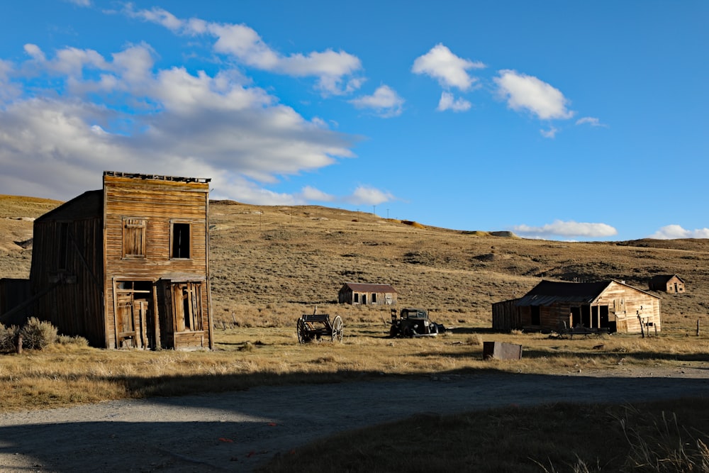 an old wooden building sitting in the middle of a field