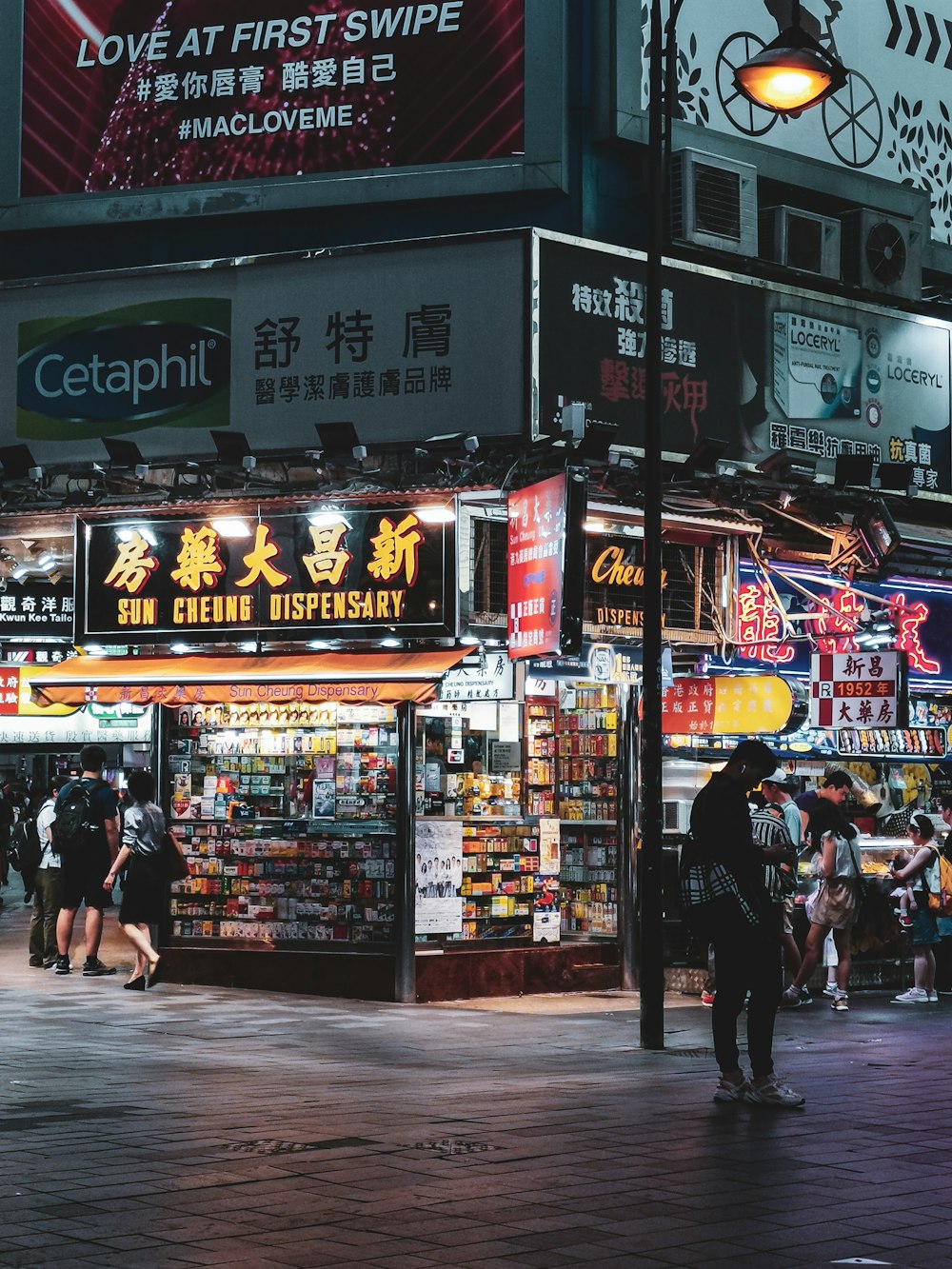 a group of people walking down a street at night