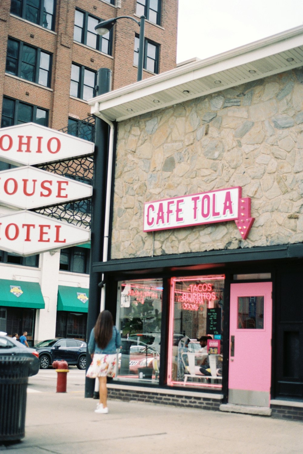 a woman is standing outside of a cafe