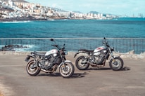 two motorcycles parked next to each other in a parking lot