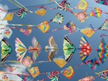 A group of vibrant kites flying together during a festival.