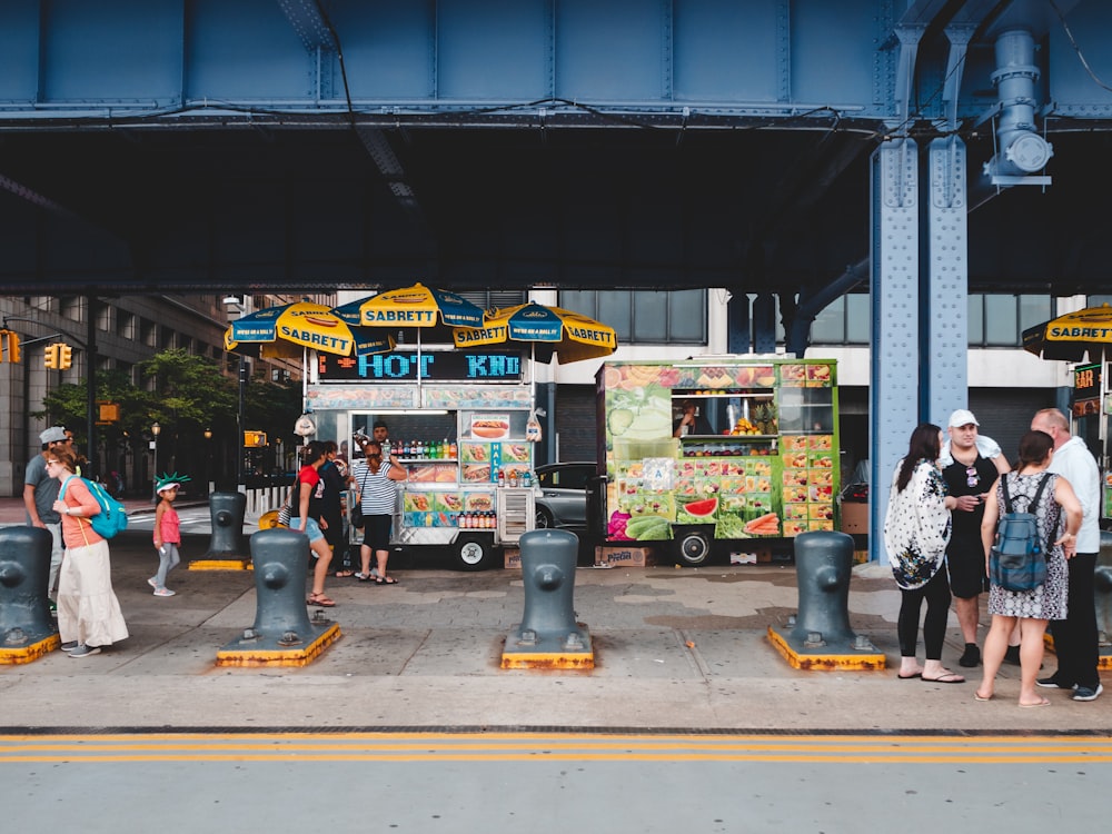 a group of people standing outside of a food truck