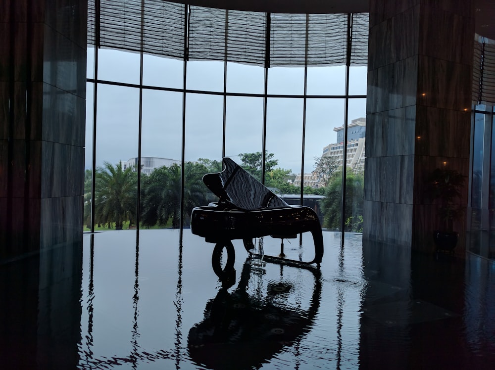 a piano sitting in front of a large window