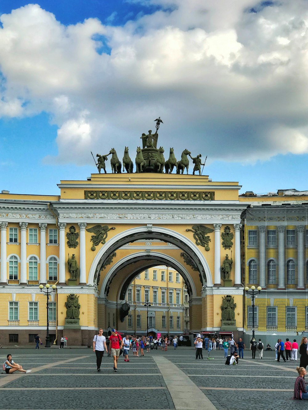 a large yellow building with a statue on top of it