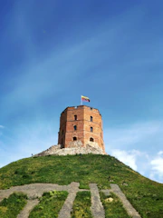 a tall brick tower sitting on top of a lush green hillside