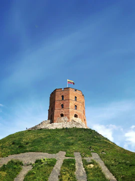 a tall brick tower sitting on top of a lush green hillside