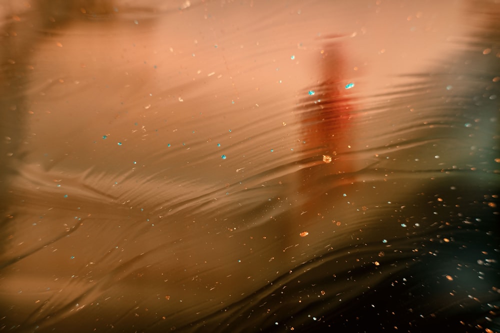 a blurry photo of a red fire hydrant in the water