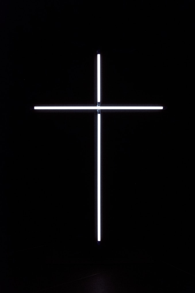 a cross that is lit up in the dark