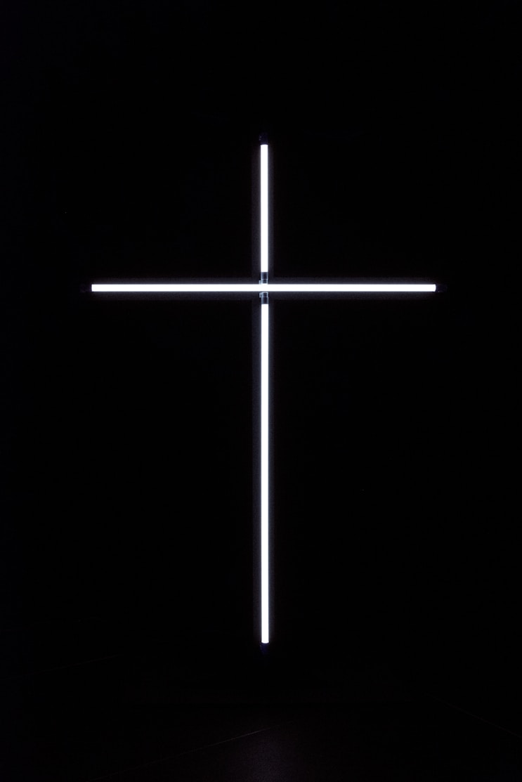 a cross that is lit up in the dark
