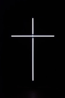 a cross that is lit up in the dark