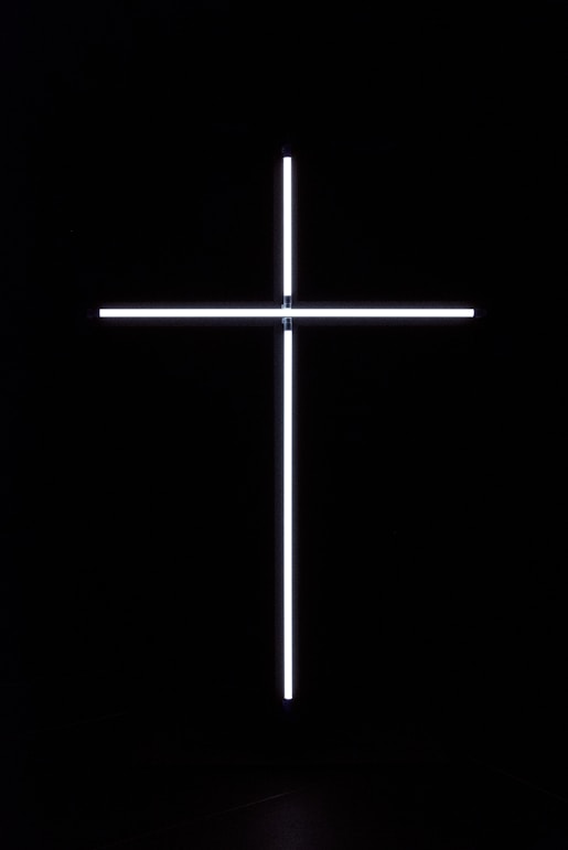 a cross that is lit up in the dark