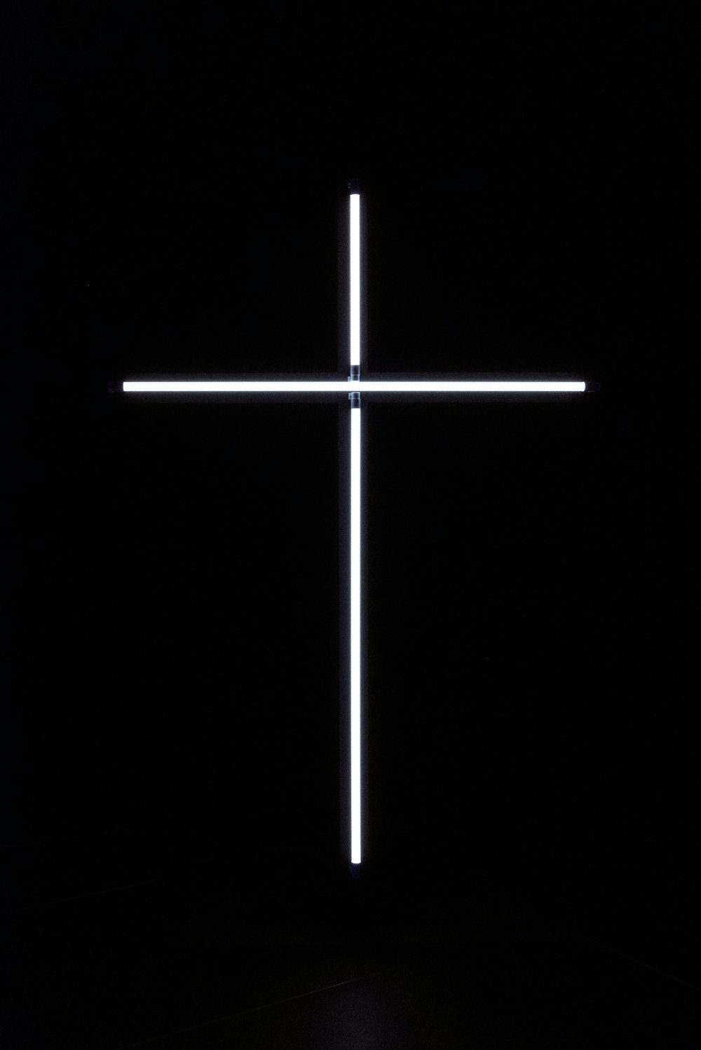 uma cruz iluminada no escuro