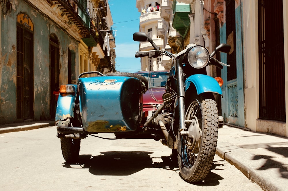 blue tricycle parked beside house