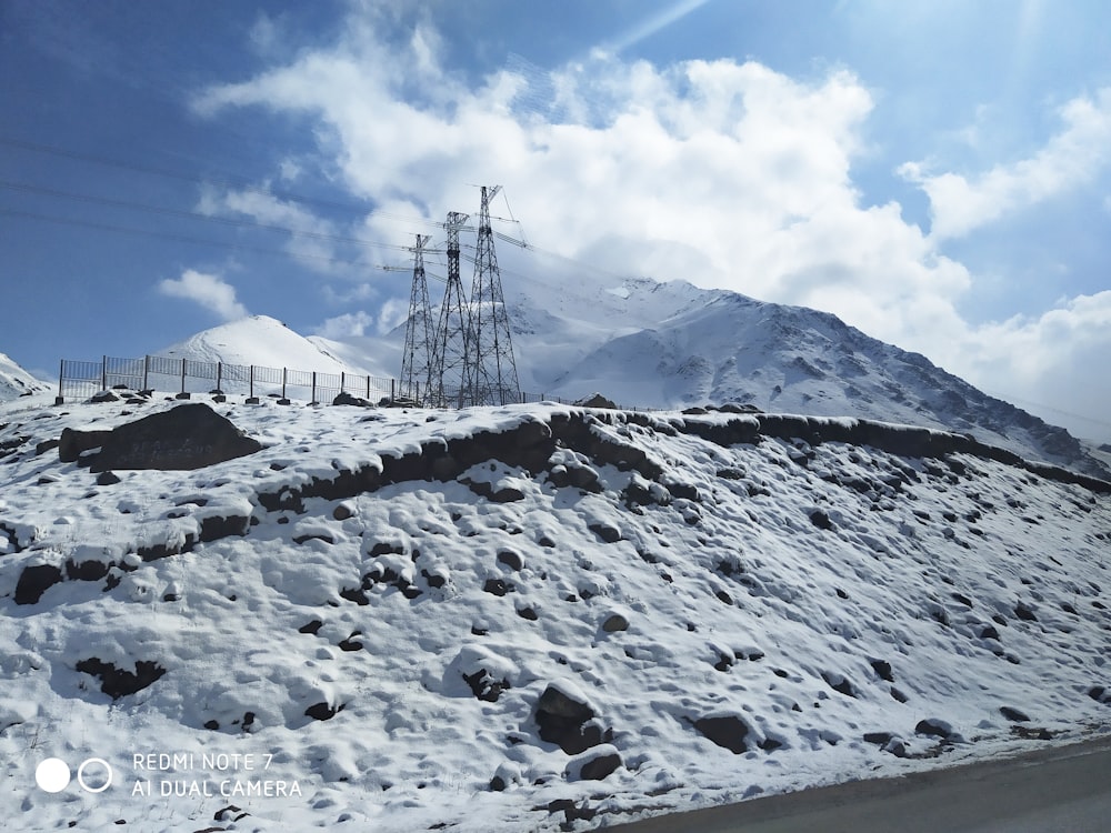 three utility tower above the hill with snow