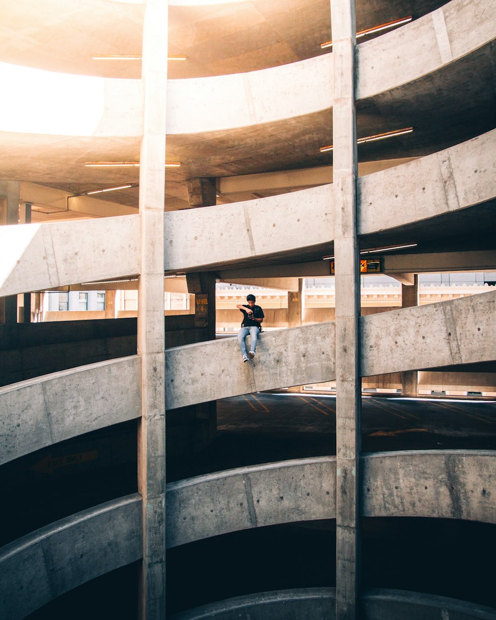 homme assis sur le mur du bâtiment pendant la journée