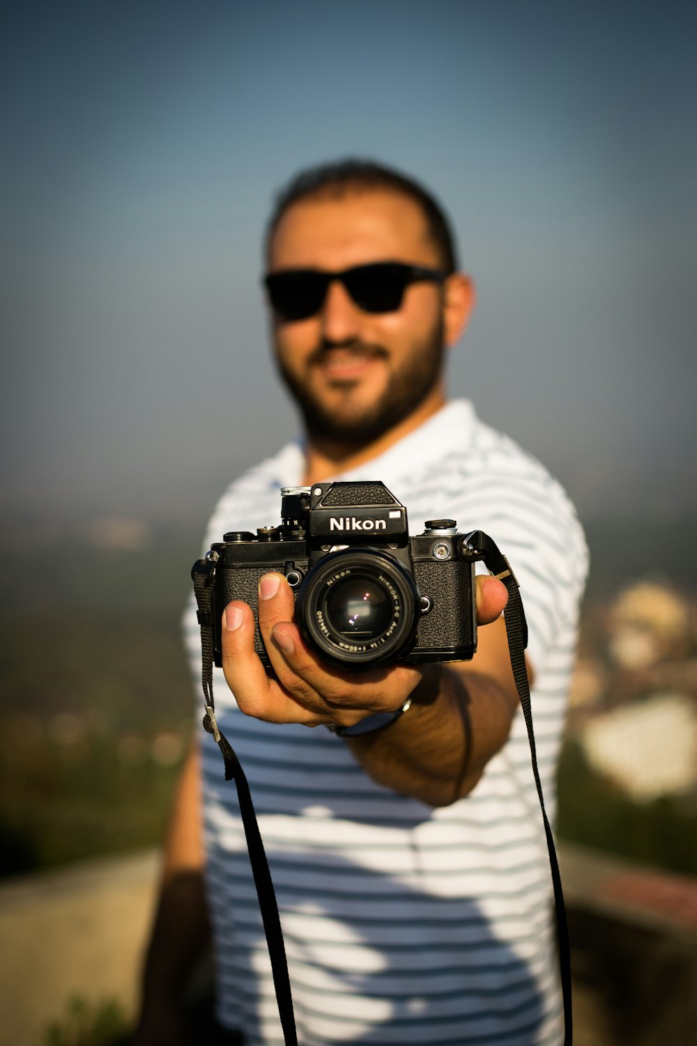 persona sosteniendo una cámara Nikon DSLR negra