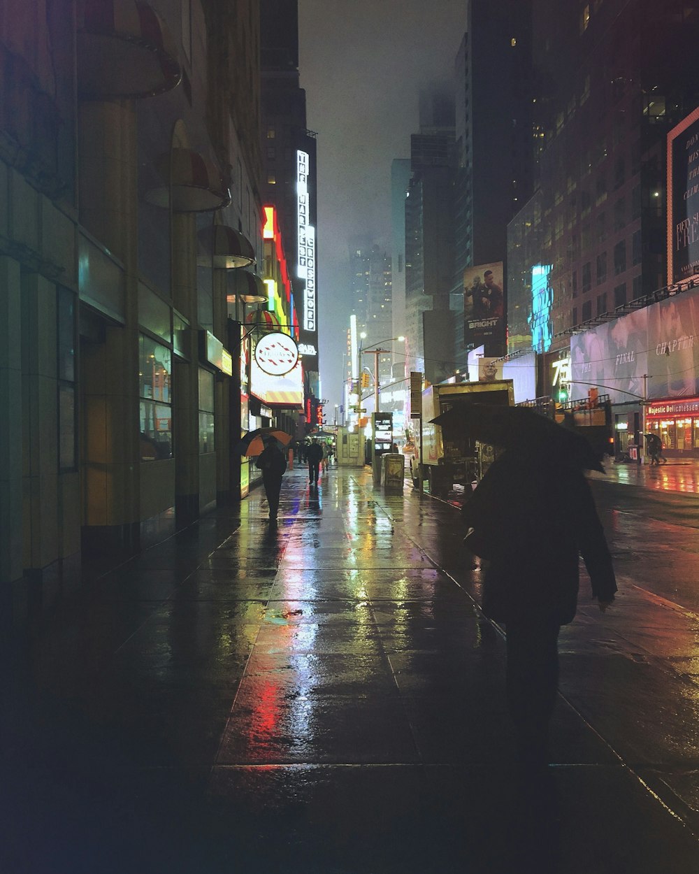 people walking on sidewalk at night