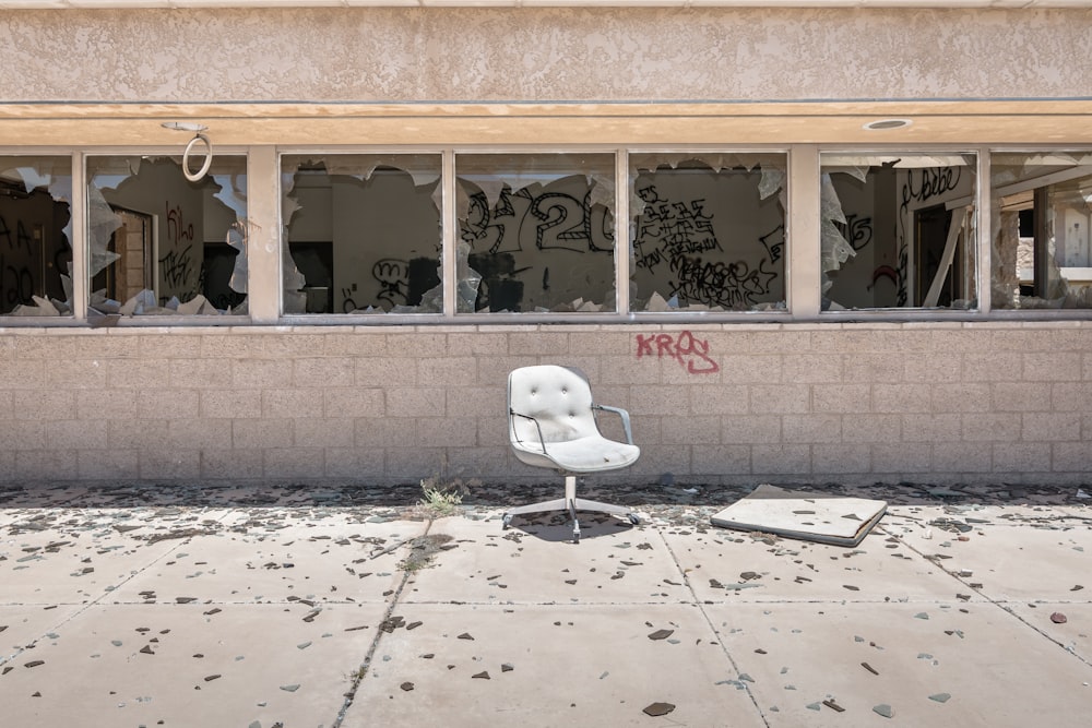 white rolling chair outside near abandoned builtind